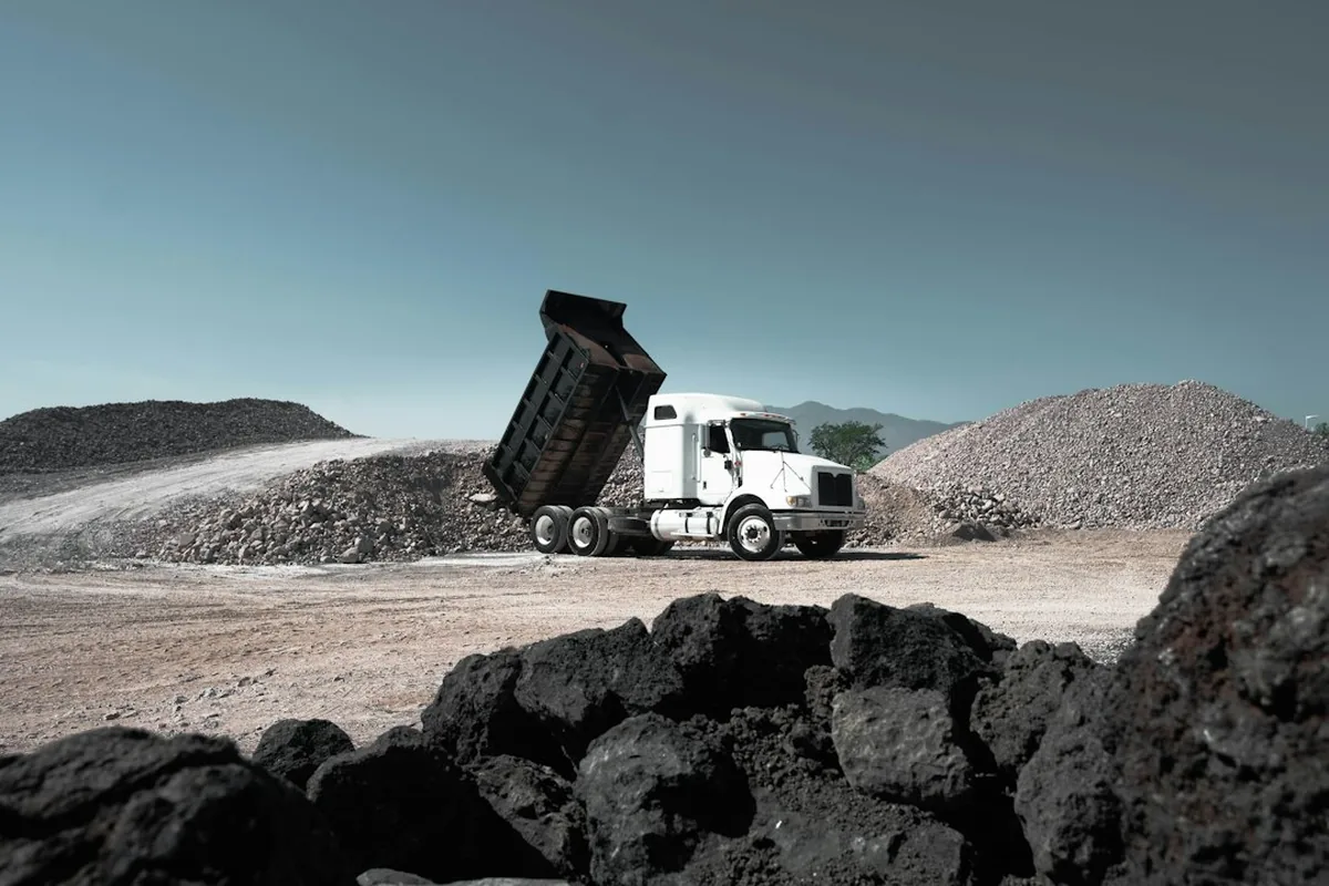 Camion porteur benne qui bascule sa charge