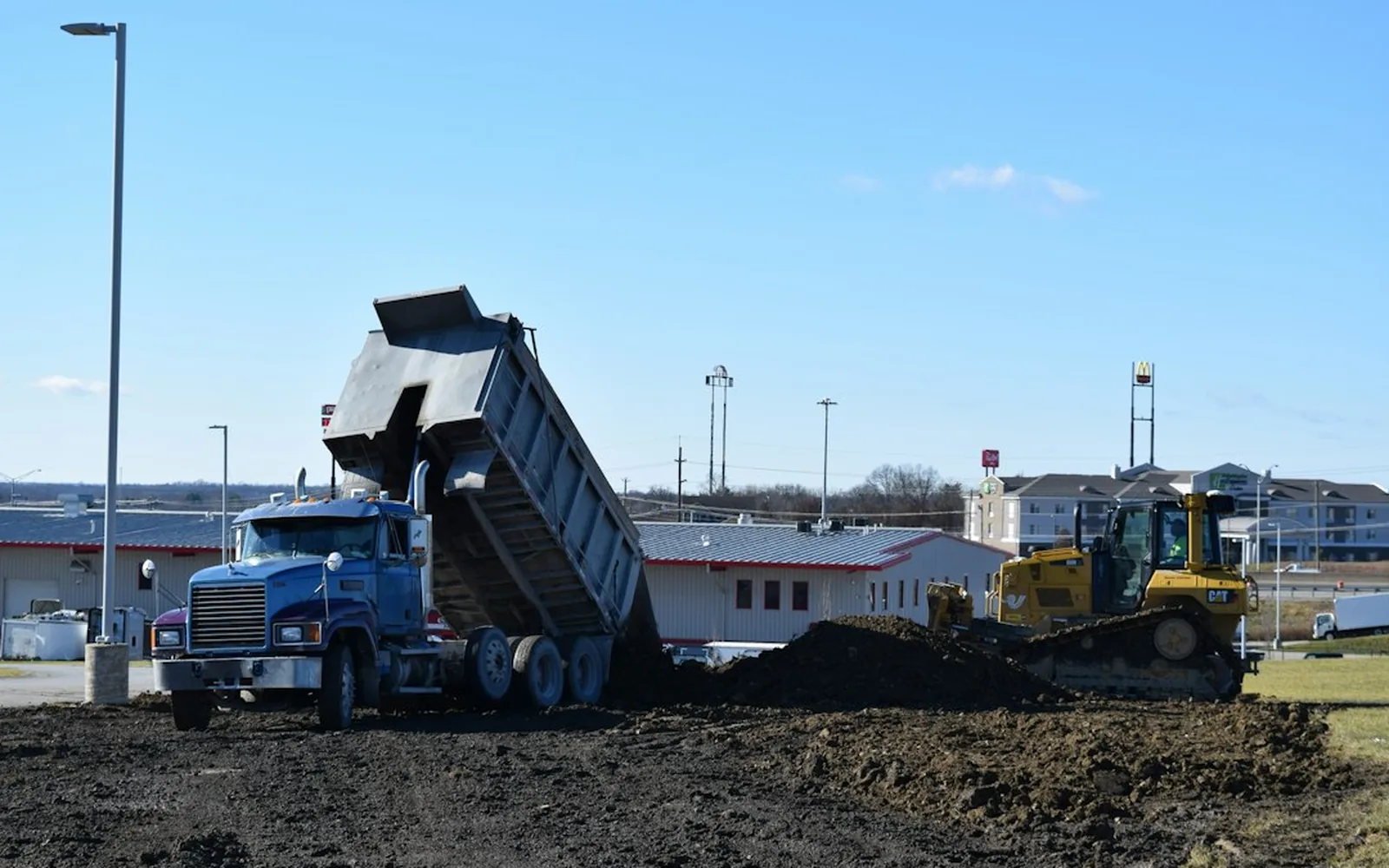 Camion benne qui bascule sa charge sur un chantier